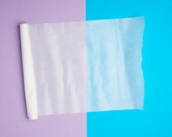 unwound white parchment baking paper on a blue purple background photo