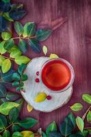 Tea with fruits and herbs in a transparent glass mug photo