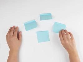 lot of blue stickers on a white background and two female hands photo