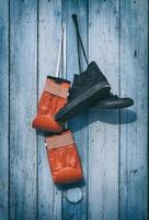 Black textile worn sneakers and red leather boxing gloves photo