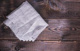 servilleta de lino gris sobre un fondo de madera marrón foto