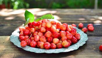 Ripe red cherry in an iron plate photo