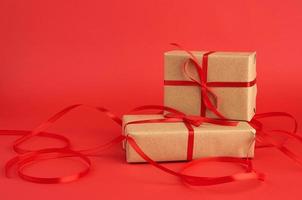 stack of boxes wrapped in brown paper and tied with a red bow photo