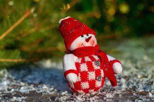 Textile Snowman on the gray wooden surfaces including snow, selective focus photo