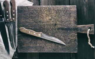 knives and brown wooden cutting board photo