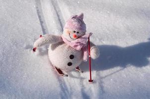 Textile snowman with snow slides down hill skiing photo