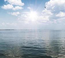 view of the sea with white fluffy clouds photo