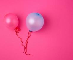 inflated blue and pink rubber balloons on a pink background photo