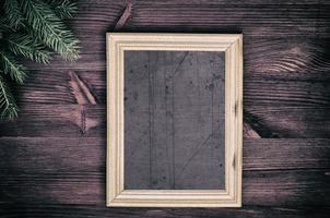 marco de madera vacío vintage con una rama de abeto en la esquina foto