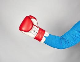 la mano del hombre lleva un guante de boxeo de cuero rojo foto