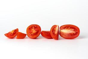 tomates enteros rojos maduros y trozos sobre un fondo blanco foto