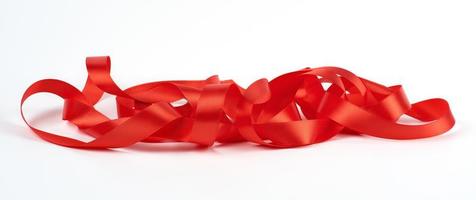 curled red satin ribbon on white background, festive backdrop photo