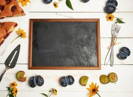 empty chalky black frame ingredients and slices of plum cake photo