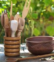 empty clay plate and various wooden kitchen objects photo