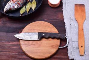 Kitchen knife on a circular cutting wooden board photo