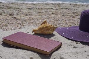 book and hat on the beach photo