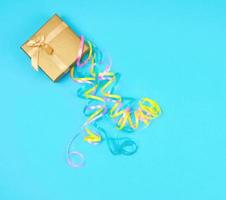 closed golden gift box with a bow on a blue background photo