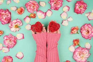 dos manos femeninas sostienen corazones rojos foto