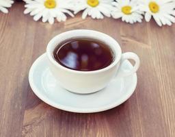 black tea in a white mug with a saucer photo