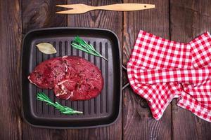 Beef steak with spices in a black square frying pan photo