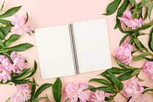 cuaderno espiral abierto con páginas en blanco sobre un fondo beige foto