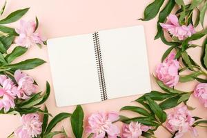 open spiral notebook with blank white pages on a beige background photo