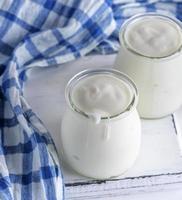 glass jars with homemade yogurt on a white wooden board photo