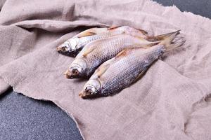 Three withered roach fish on the gray napkin photo