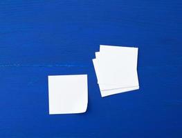 hoja de papel blanca vacía sobre un fondo de madera azul foto