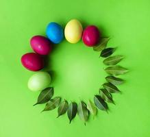 huevos de pascua y hojas verdes. roseta para texto. tarjeta. felicitaciones foto