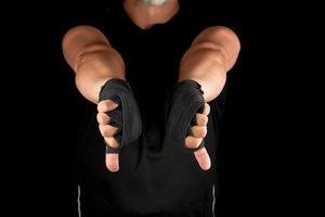 adult athlete in black uniform and hands rewound with textile bandage photo