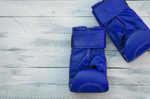 pair of blue boxing gloves on a white wooden surface photo