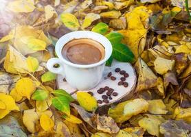 taza blanca con café negro en un tocón foto