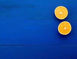 dos mitades de naranja jugosa madura sobre un fondo de madera azul oscuro foto