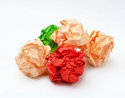 multicolored crumpled paper balls on white background photo