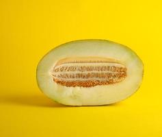 piece of ripe melon with seeds on a yellow background photo