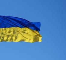 la bandera textil ucraniana se desarrolla contra el cielo azul foto