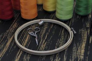 Hoop, scissors and colored threads photo