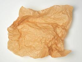 crumpled piece of brown paper sheet on white backgroun photo