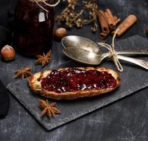 toast with raspberry jam, two iron spoons photo