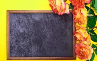 Empty black frame with a bouquet of yellow roses photo