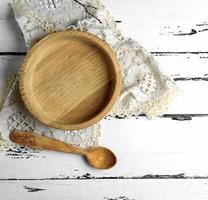 empty wooden round plate and wooden spoon photo