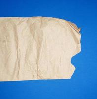 torn brown sheet of paper on a blue background photo