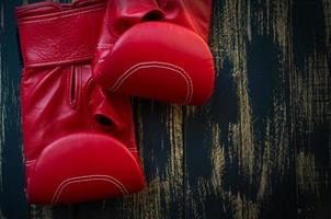 guantes de boxeo de cuero rojo sobre un fondo negro foto