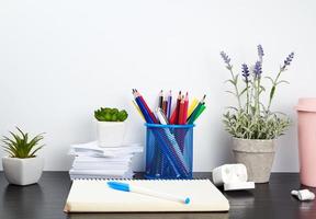 spiral notebooks, ceramic cup with coffee and colorful pencils photo