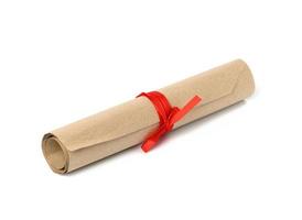 rollo enrollado de papel kraft marrón y atado con cinta roja foto