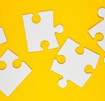 blank white big puzzles on yellow background, flat lay photo