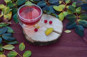 Tea with a viburnum in a transparent mug photo