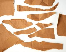 torn brown pieces of parchment paper on a white background photo