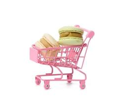 baked macarons on pink metal trolley isolated on white background photo